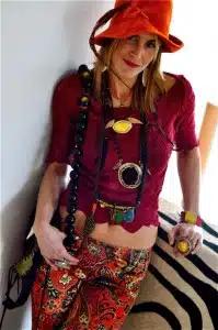 Person in vibrant, eclectic outfit and hat.