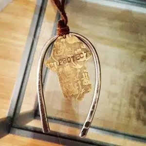 Horseshoe pendant with "PROTECT" inscription.