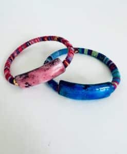 Two colorful bracelets with ceramic beads on patterned bands.