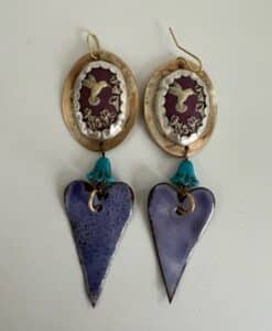 Handcrafted earrings with purple hearts and bird motifs in gold and turquoise.