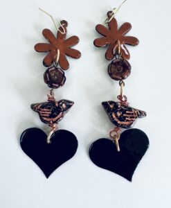 Handcrafted earrings with flower, bird, and heart motifs in black and copper tones.