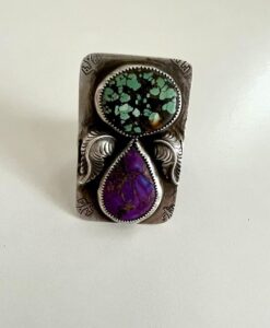 Silver ring with turquoise and purple stones, decorated with intricate designs.