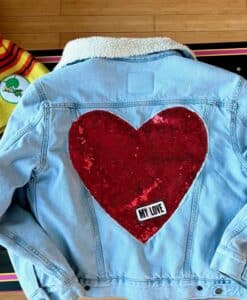Denim jacket with large red heart and 'My Love' patch on the back.