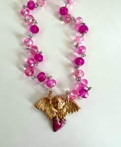 Necklace with pink beads and a gold angel pendant holding a heart.