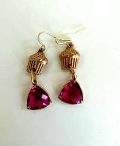 Earrings with cupcake-shaped tops and dangling red triangular gems.