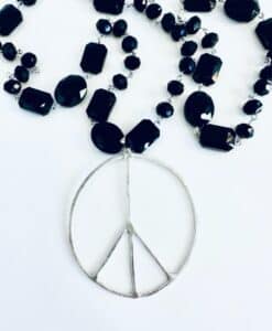 Black bead necklace with a silver peace sign pendant.