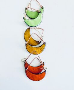 Colorful crescent-shaped earrings in green, yellow, and orange hues with wire details.