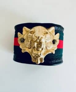 Black leather bracelet with gold tiger head and red and green stripes.