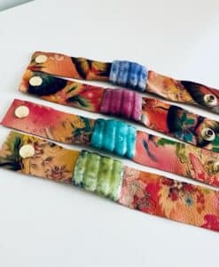 Colorful leather wristbands with textured, padded centers and snap buttons.