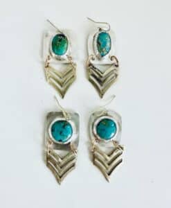 Two pairs of silver earrings with turquoise stones and chevron designs.