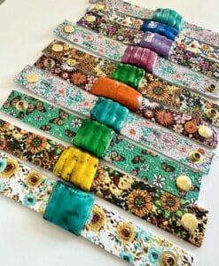 Colorful floral wristbands with textured beads arranged in rows.