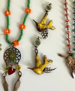 Handmade necklaces with colorful beads and bird pendants.