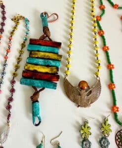 Colorful beaded necklaces with unique pendants, including turquoise and winged designs.