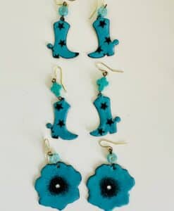 Three pairs of turquoise earrings with black star and flower designs.