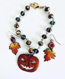 Halloween-themed jewelry set with pumpkin and autumn leaf designs.