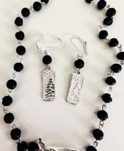 Black bead necklace and matching silver earrings with tree design.