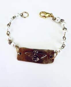 Bracelet with a bee design and pearl-like beads.