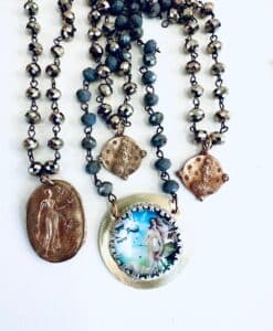 Three artistic necklaces with unique pendants and beads.