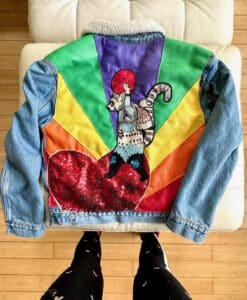 Colorful denim jacket with a vibrant cat and heart design on the back.