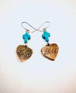 Earrings with golden heart charms inscribed with 'love' and 'fear' and turquoise cross beads.