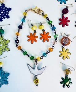 Colorful beaded bracelet with a bird charm and matching flower earrings.