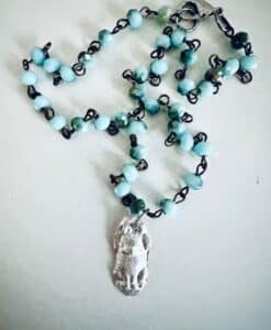 Beaded necklace with blue-green beads and a silver pendant.