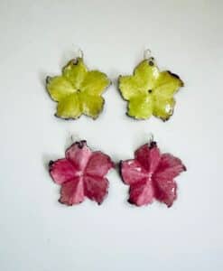 Four colorful flower-shaped earrings in green and pink hues.