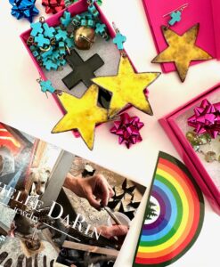 Colorful star-shaped cookies and puzzle pieces in boxes with a rainbow-themed book.