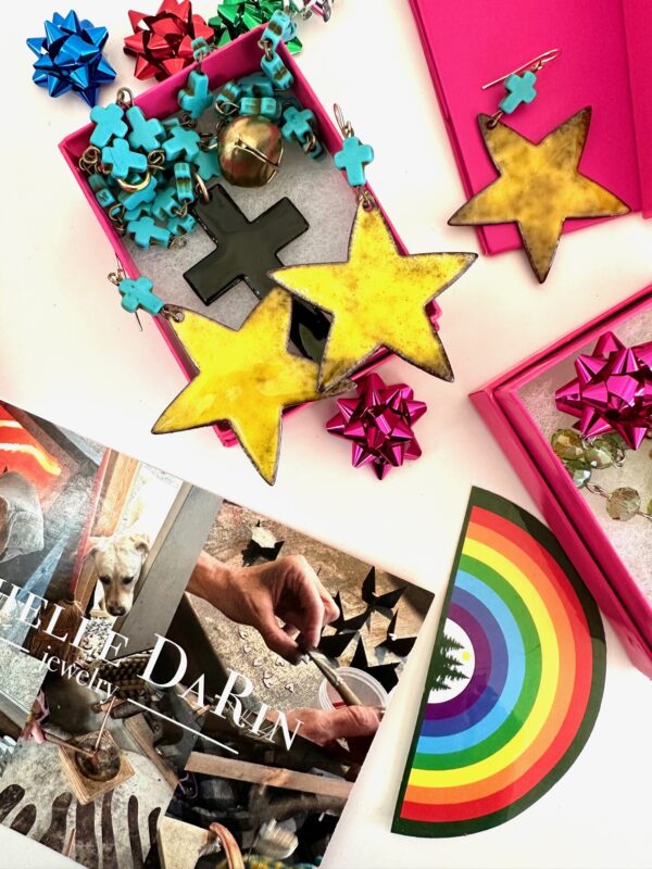 Colorful star-shaped cookies and puzzle pieces in boxes with a rainbow-themed book.