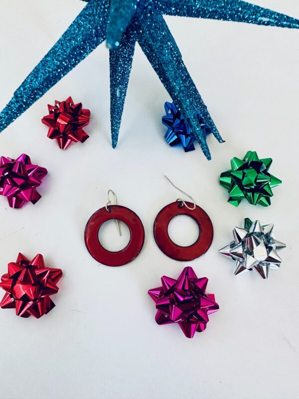 Red circular earrings surrounded by colorful shiny gift bows.
