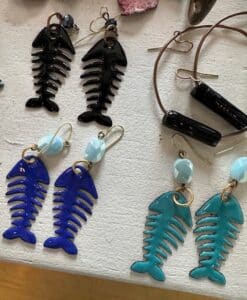 Colorful fishbone dangle earrings displayed on table